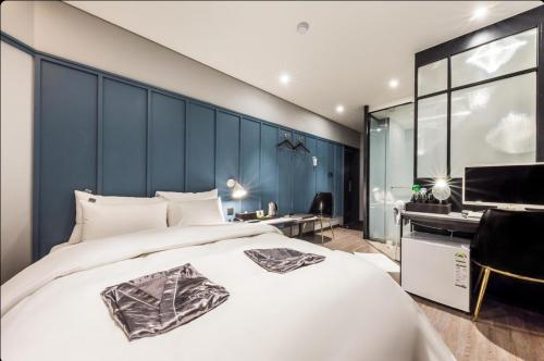 a bedroom with a large white bed and a desk at STYLE Hotel in Seoul