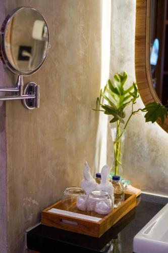 a bathroom sink with a wooden tray with a mirror at Subu Utamas Villas in Ubud