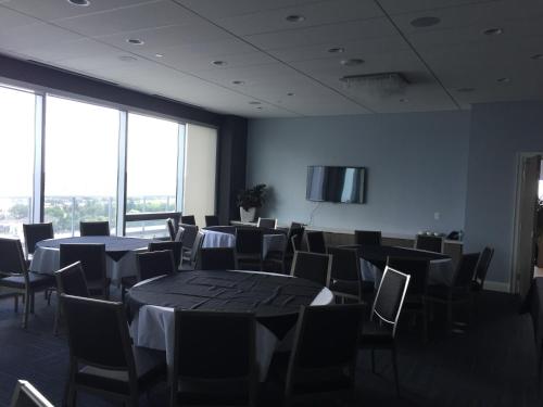 a room with tables and chairs and a flat screen tv at Liberty Suites in Thornhill