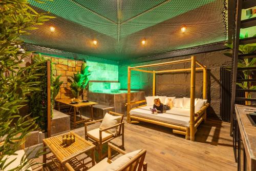 a woman sitting on a bed in a room at INTENSE Senses Experience - Suites wellness avec piscine, jacuzzi, sauna, billard etc in Manage