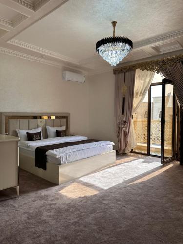 a bedroom with a large bed and a chandelier at Ark hotel PREMIUM in Bukhara