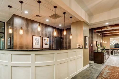 a large lobby with a bar with lights at Garrison Hotel & Suites Dover-Portsmouth, an Ascend Collection Hotel in Dover