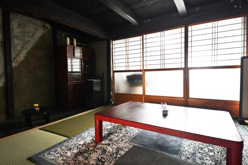 a living room with a table and a large window at minshuku studio enishi in Nagahama
