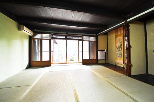 an empty room with large windows in a building at minshuku studio enishi in Nagahama