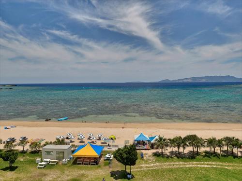 an overhead view of a beach with umbrellas and the ocean at Miyuki Hamabaru Resort in Onna
