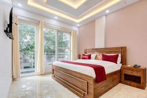 a bedroom with a bed and a large window at Super Hotel Pari Chowk Formerly The Divine KRC in Greater Noida