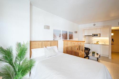 a bedroom with a white bed and a palm tree at nice seafront apartment in Almuñécar