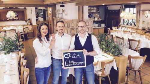 a group of three people holding a sign in a restaurant at Hotel Rosenbusch in Großheubach