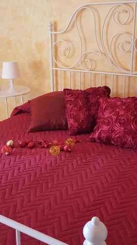 a bed with a red comforter and pillows on it at La Casa di Ninna Affittacamere in Ariano Irpino