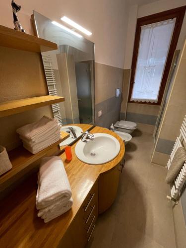 a bathroom with a sink and a mirror and two toilets at MONTECAMPI casa di charme in Meda