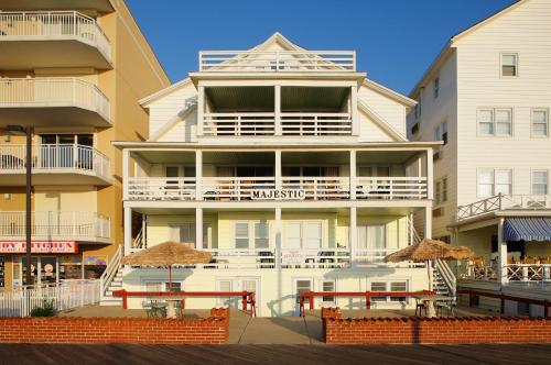 a tall white building with umbrellas in front of it at Majestic Hotel & Apartments in Ocean City