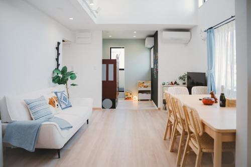 a living room with a white couch and a table at Mulan Stay 松尾大社 in Kyoto
