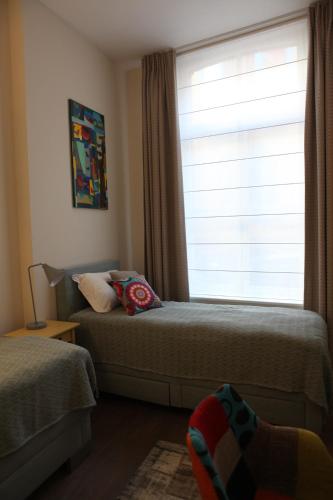 a bedroom with two beds and a window at ZevenVrijeDagen in Ghent