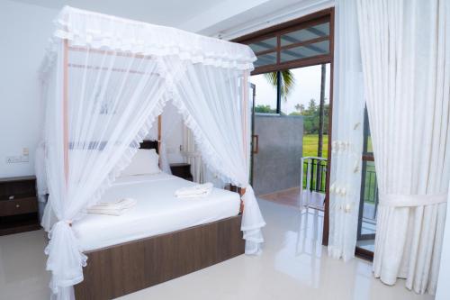 a bedroom with a bed with a canopy at Heaven Upon Rice Fields in Anuradhapura