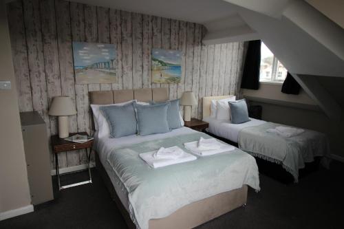 a bedroom with two beds with towels on them at Cornerhouse Apartments 4 Sleeps 5 in Llandudno