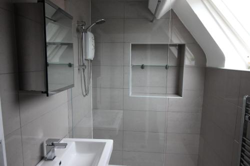 a bathroom with a sink and a shower at Cornerhouse Apartments 4 Sleeps 5 in Llandudno
