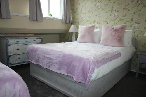 a bedroom with a large bed with a purple blanket at Cornerhouse Apartments 5 Sleeps 5 in Llandudno
