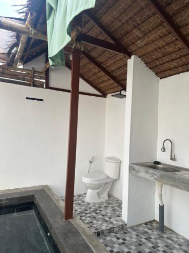 a bathroom with a toilet and a sink at Mias Home in Sunggal