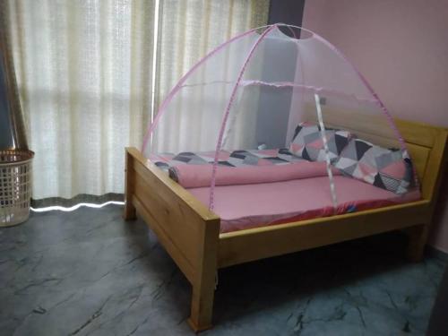 a small bed with a canopy in a room at Cosy Homes in Gulu
