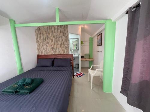 a bedroom with a bed with a green headboard at TopCats Fishing Resort in Taling Ngam Beach