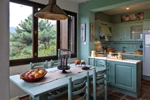 una cocina con una mesa con un bol de fruta. en Centaur Suites & Maisonettes en Miléai