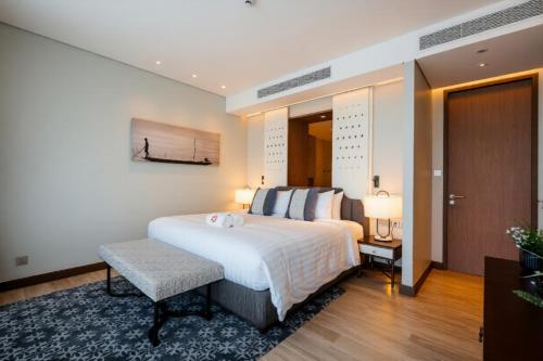 a bedroom with a bed and a table and two lamps at ANGSANA Oceanview Apartments with a privat pool in Laguna area in Bang Tao Beach
