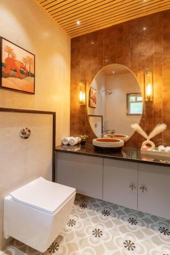 a bathroom with a toilet and a large mirror at Olive Resort - Sillari Pench in Silāri