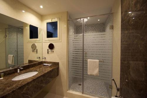 ein Badezimmer mit Glasdusche und Waschbecken in der Unterkunft ابات للشقق المخدومة ABAT Serviced Apartment in Riad