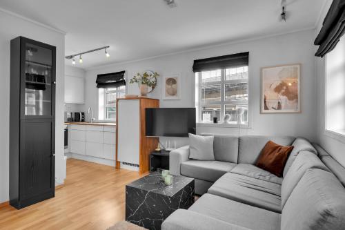 a living room with a gray couch and a kitchen at Northstay - Skansegata Apartments, Apartment B l One-Bedroom in Tromsø