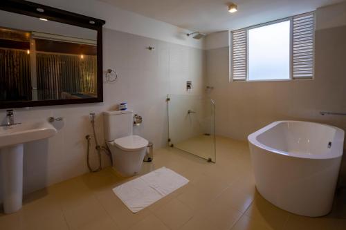 a bathroom with a tub and a toilet and a sink at The Pinnacle Ella Boutique Hotel and Spa in Ella