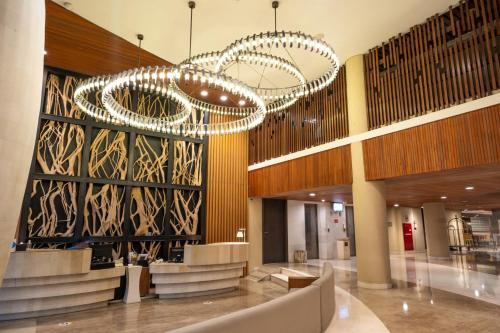 a large lobby with a chandelier in a building at Bedrock Hotel Kuta in Kuta
