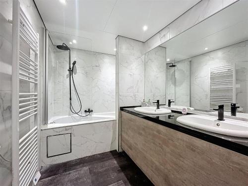 a bathroom with two sinks and a tub and a shower at DURBUY au "trois marcassins" in Durbuy