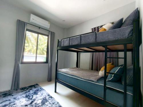 a bedroom with two bunk beds and a window at Tanner House Krabi in Ban Klang