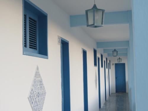 a hallway with blue and white walls and doors at La Suite Praia Hotel in Caucaia