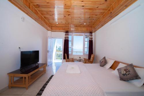 a living room with a bed and a flat screen tv at Forest rest house Tannu Jubbar - Ecotourism in Kanethi
