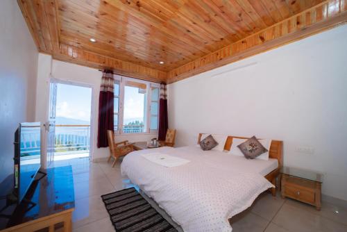 a bedroom with a large bed with a wooden ceiling at Forest rest house Tannu Jubbar - Ecotourism in Kanethi