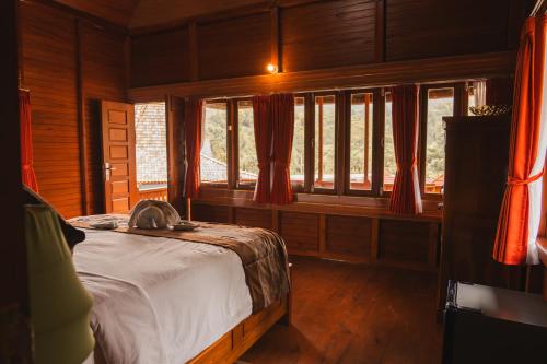 a bedroom with a bed in a room with windows at Munduk Seming Cottages in Munduk