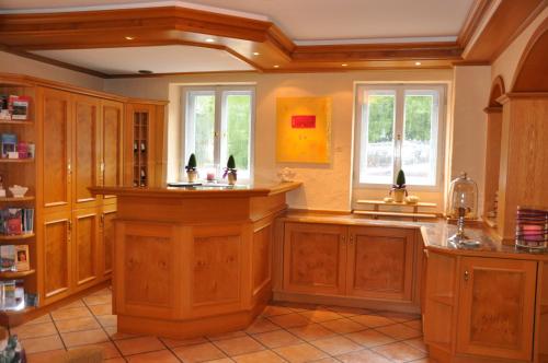 a large kitchen with wooden cabinets and windows at Hotel Fischerhaus in Starnberg