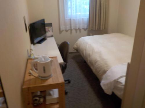 a hotel room with two beds and a desk with a computer at Hotel Crown Hills Katsuta Omotechoten in Hitachinaka