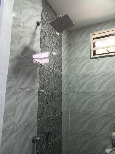a shower in a bathroom with a stone wall at Sri Biah Homestay in Kuala Berang