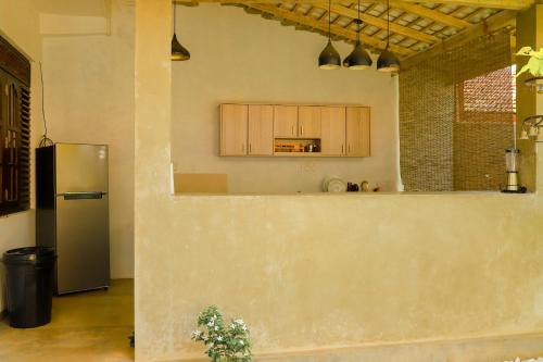 a kitchen with a refrigerator and a counter top at AYUBELLO hostel & suites in Ahungalla