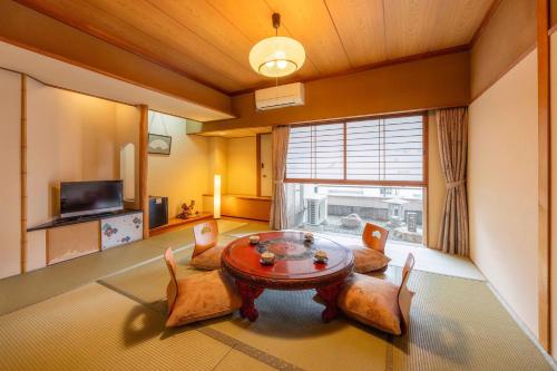 a living room with a table and chairs and a window at Osaka Ryokan Kuramoto in Osaka
