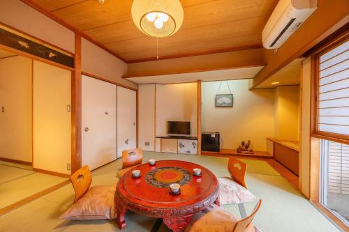 a dining room with a table and chairs in a room at Osaka Ryokan Kuramoto in Osaka