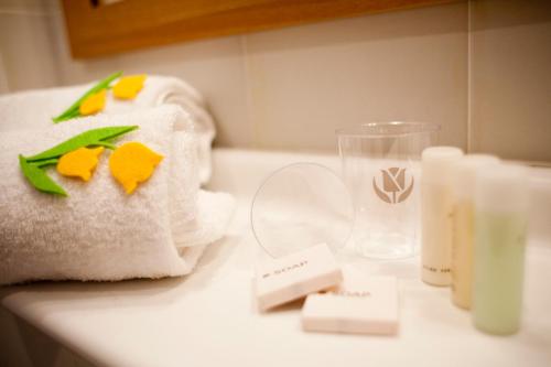 een badkamerbar met een handdoek en een glas water bij Tulip Inn Turin South in Moncalieri