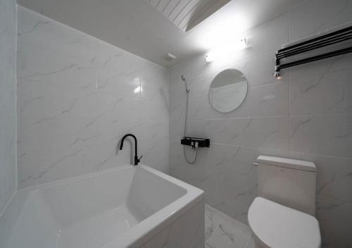 a white bathroom with a tub and a toilet at Hasen Dangjin Tourist Hotel in Dangjin