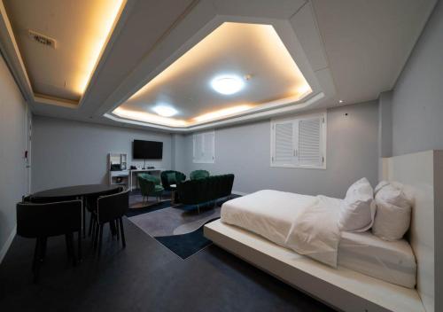 a bedroom with a bed and a table and chairs at Hasen Dangjin Tourist Hotel in Dangjin