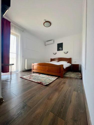 a bedroom with a bed and a wooden floor at Casa TeoDora Caciulata in Căciulata