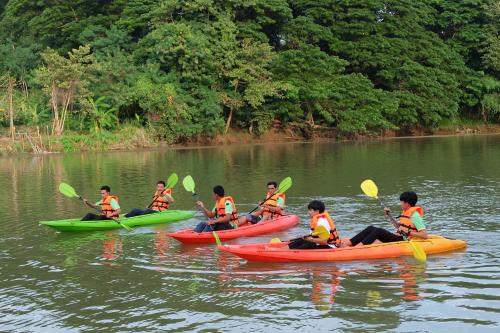 a group of children in kayaks on a river at Princess River Kwai Hotel in Kanchanaburi