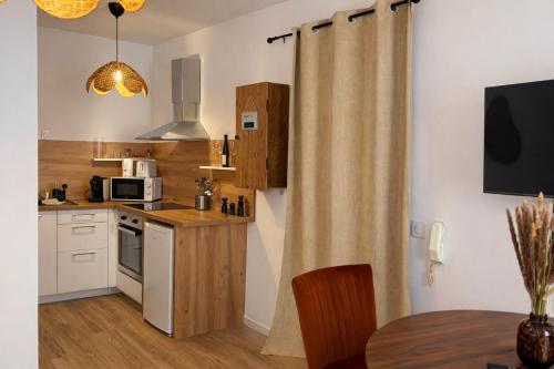 a small kitchen with a table and a microwave at Little Wild - Centre Ville in Saverne