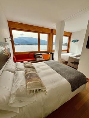 a bedroom with a large bed with a large window at Posada del Agua in El Barraco